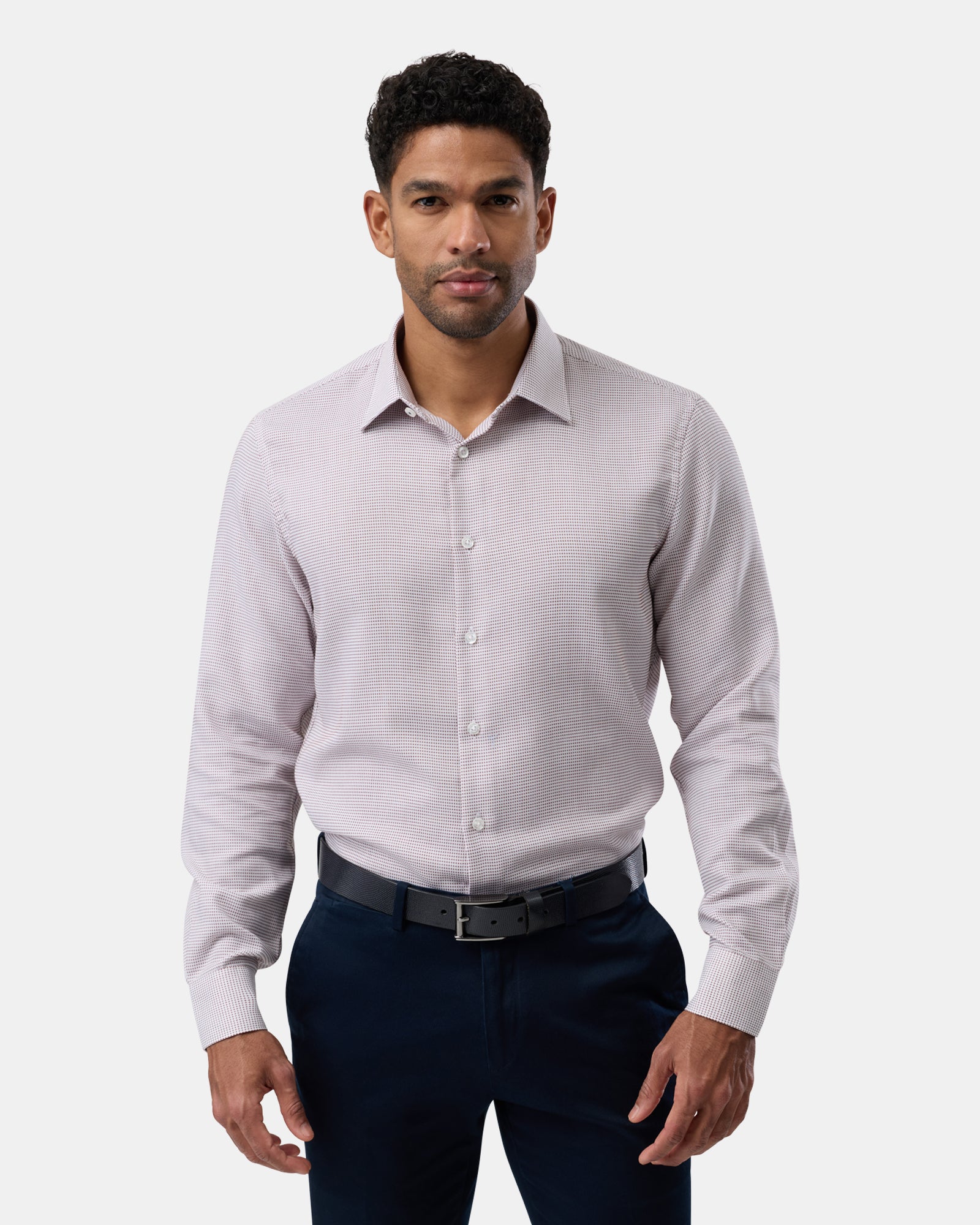 Wearing a brown subtly patterned shirt, man faces forward, tailored and smart