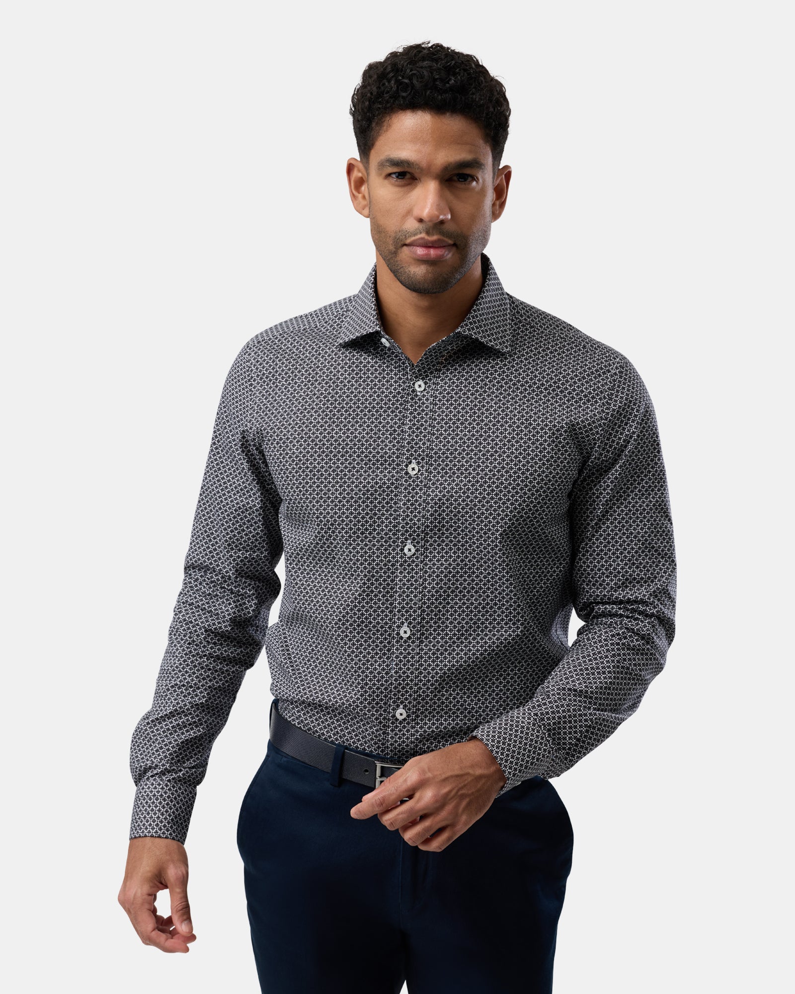 Man wearing a black patterned slim-fit shirt, viewed from the front