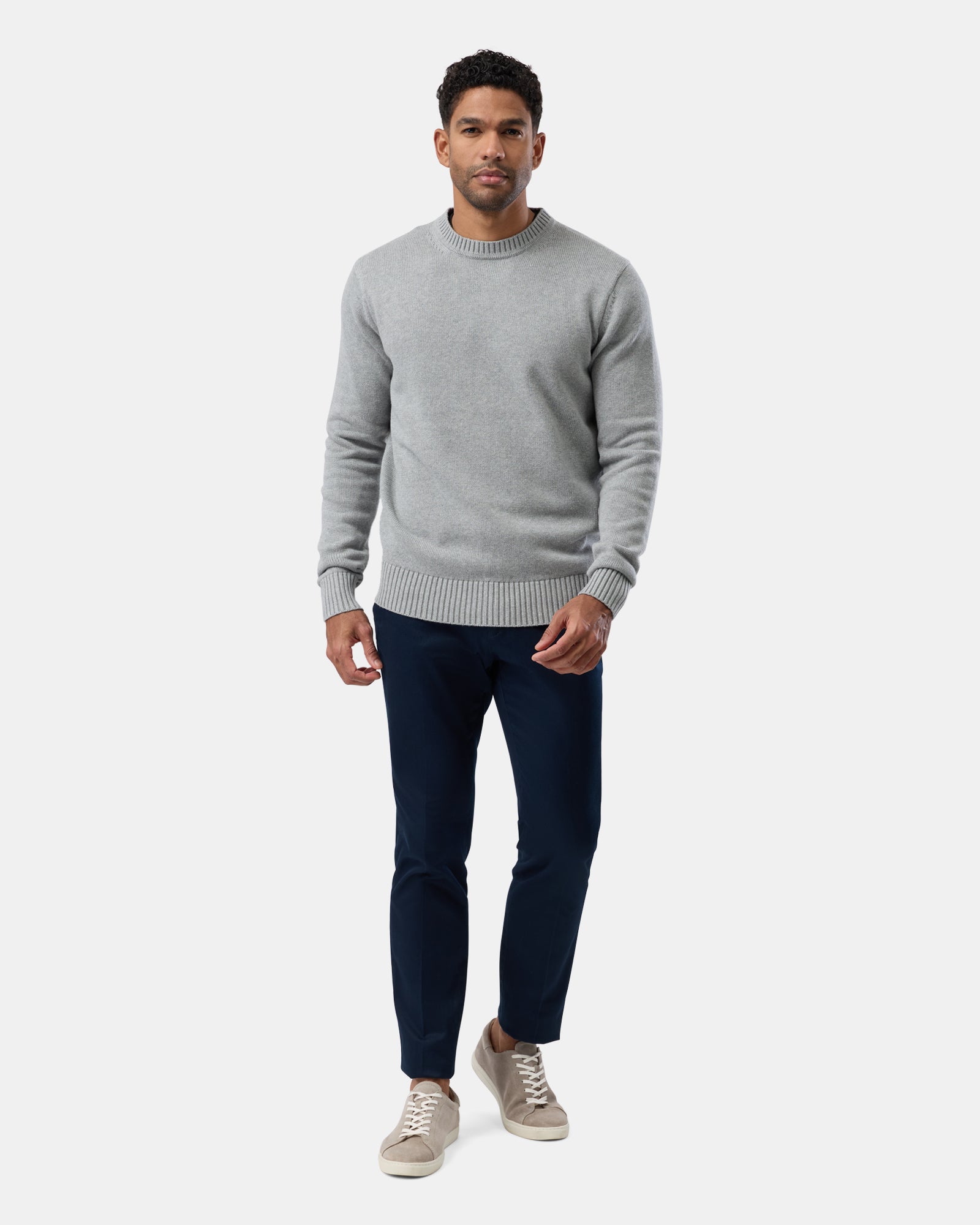 Person styled in grey crew neck sweater, full view