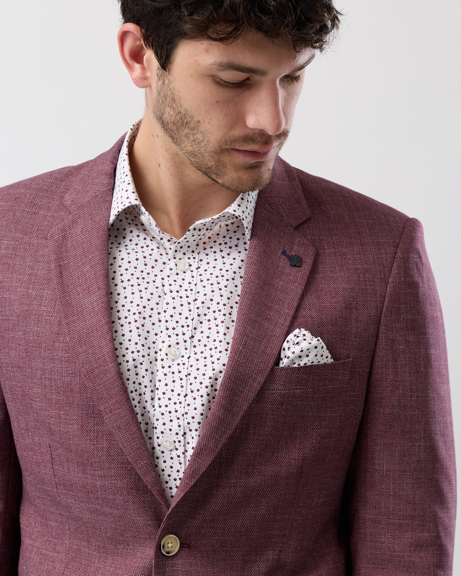 Close-up of burgundy two-button blazer, detailed stitching and buttons