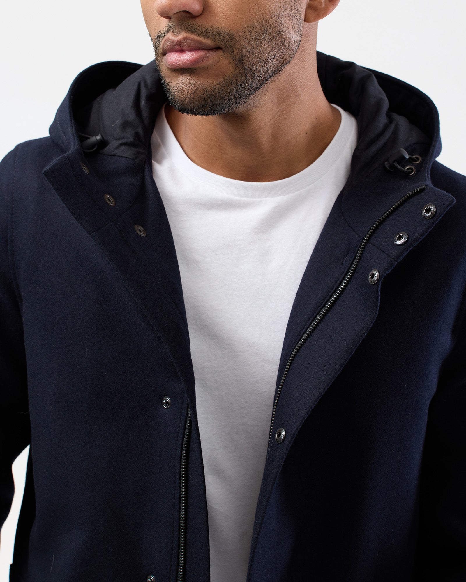 Detailed view of navy hooded overcoat fabric and hood