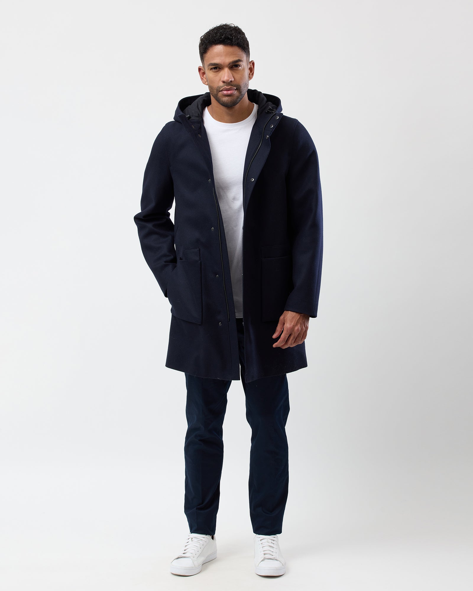 Full length of man wearing navy hooded wool blend overcoat, complete outfit