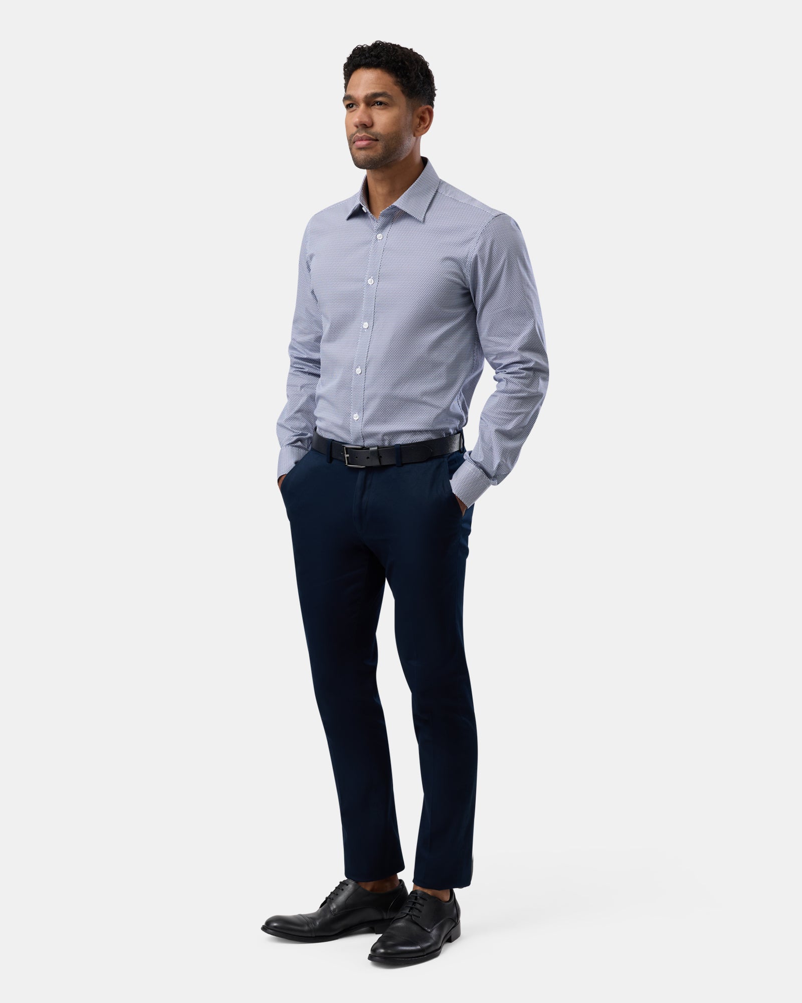 Full-length view of man wearing blue geometric stretch performance shirt, complete outfit