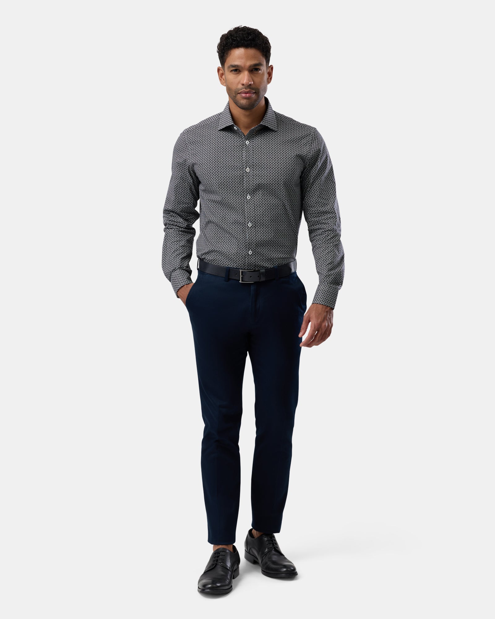 Full-length view of man wearing black patterned slim-fit shirt, complete outfit