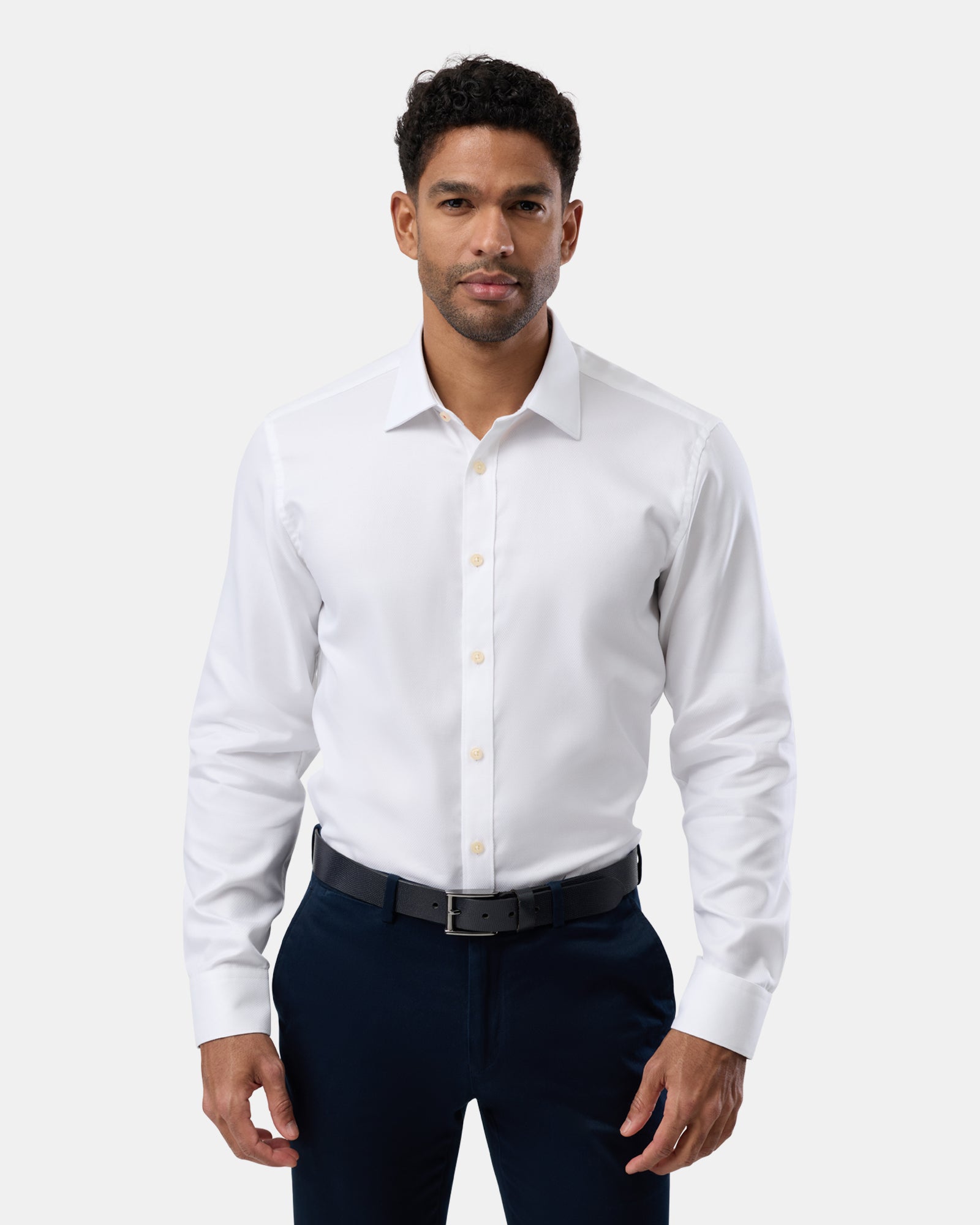 Man wearing a plain white slim-fit shirt, seen from the front, crisp tailored fit