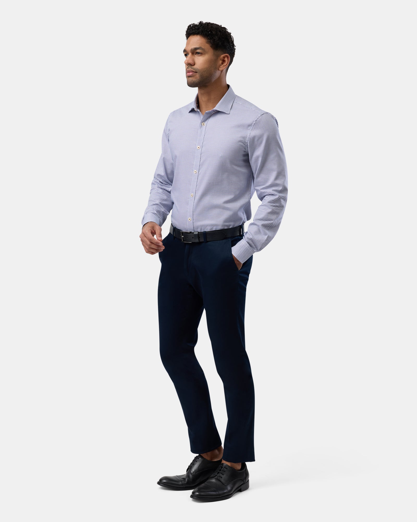 Full-length view of man wearing blue slim-fit checkered business shirt, complete professional outfit