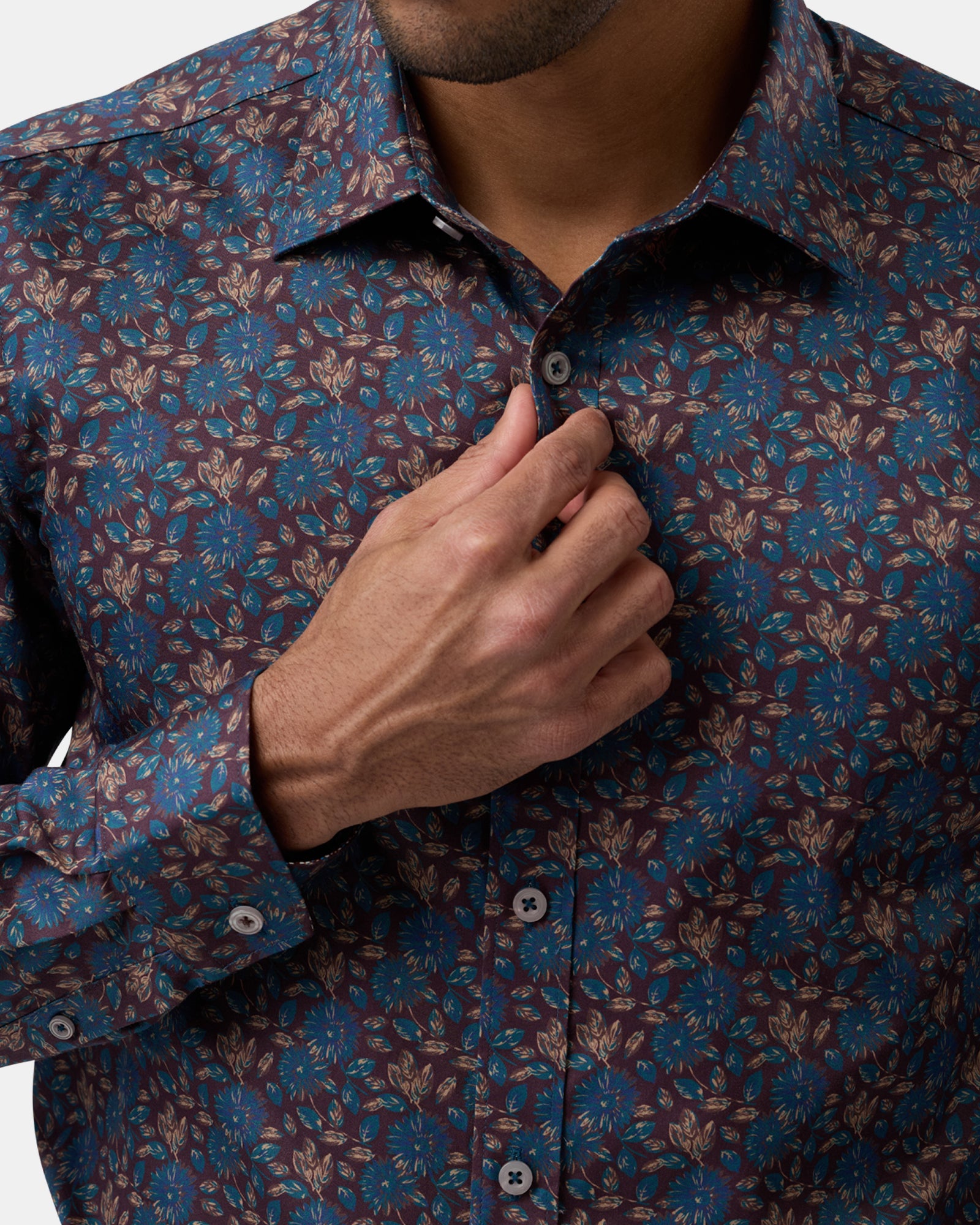 Close-up highlighting brown floral patterned shirt, fabric texture, and buttons