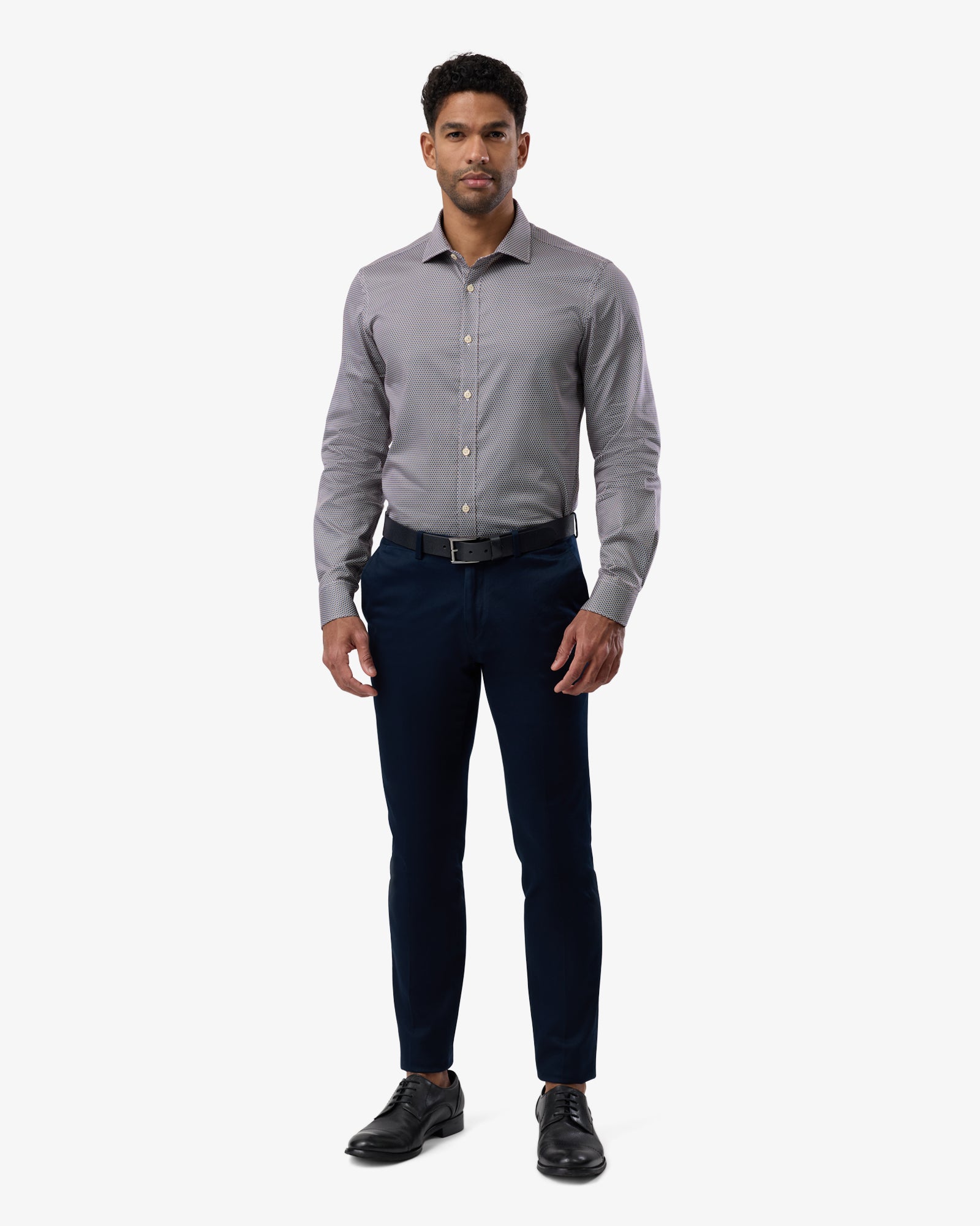 Full-length view of man wearing brown slim-fit business shirt with subtle pattern, complete outfit