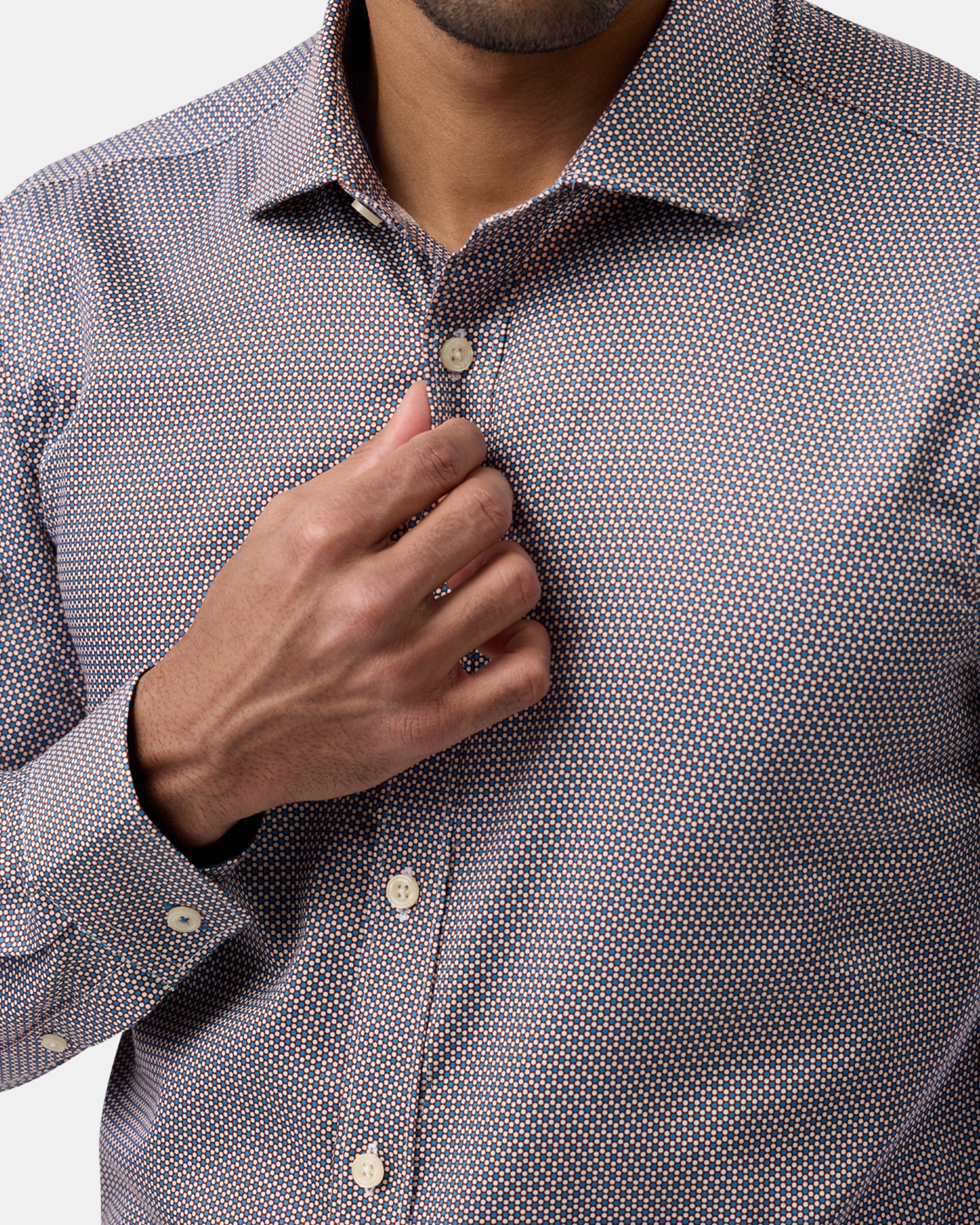Close-up highlighting brown slim-fit business shirt’s subtle pattern and button detail