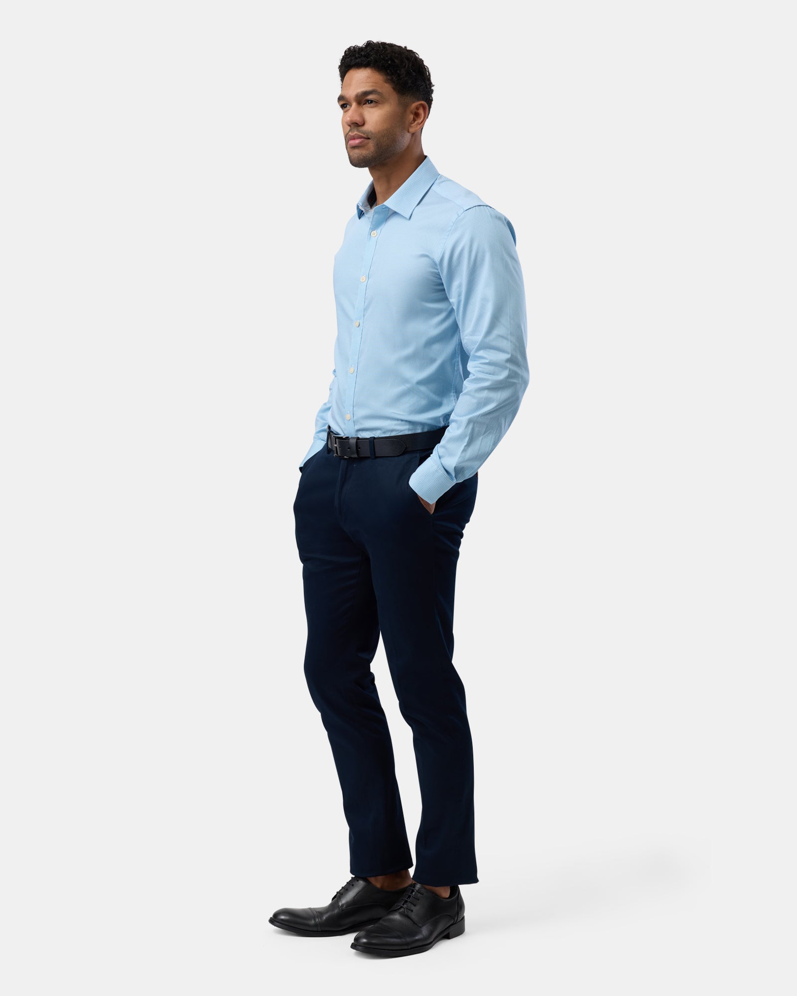 Full length of man wearing blue slim-fit business shirt with subtle pattern, complete outfit