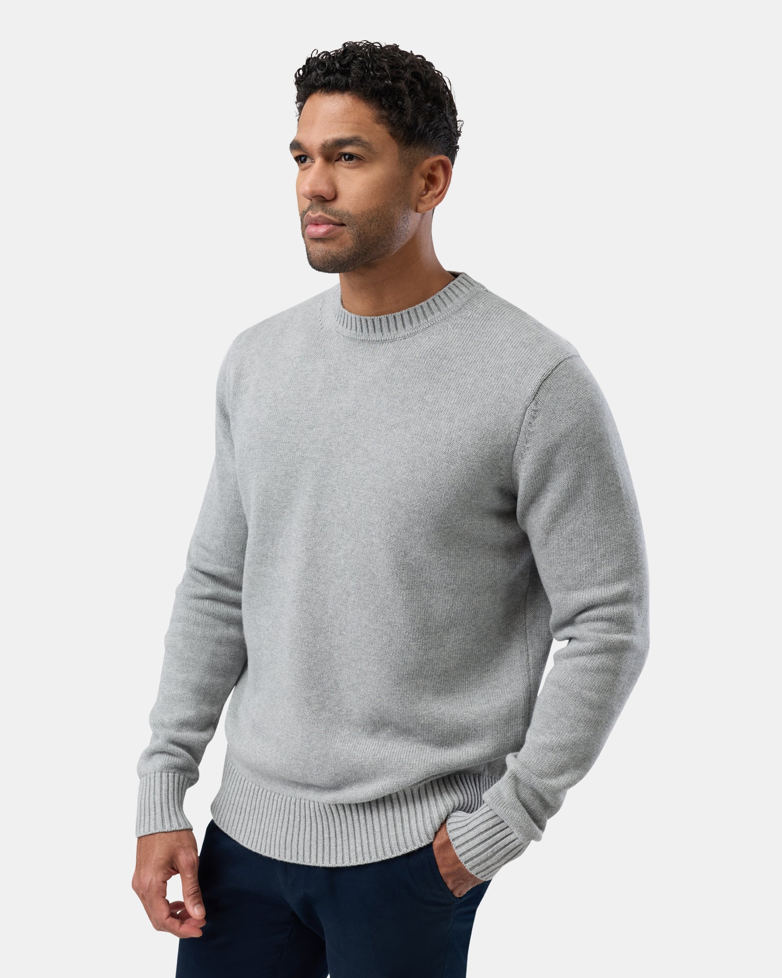 Man wearing a gray cotton crew neck sweater, cropped view