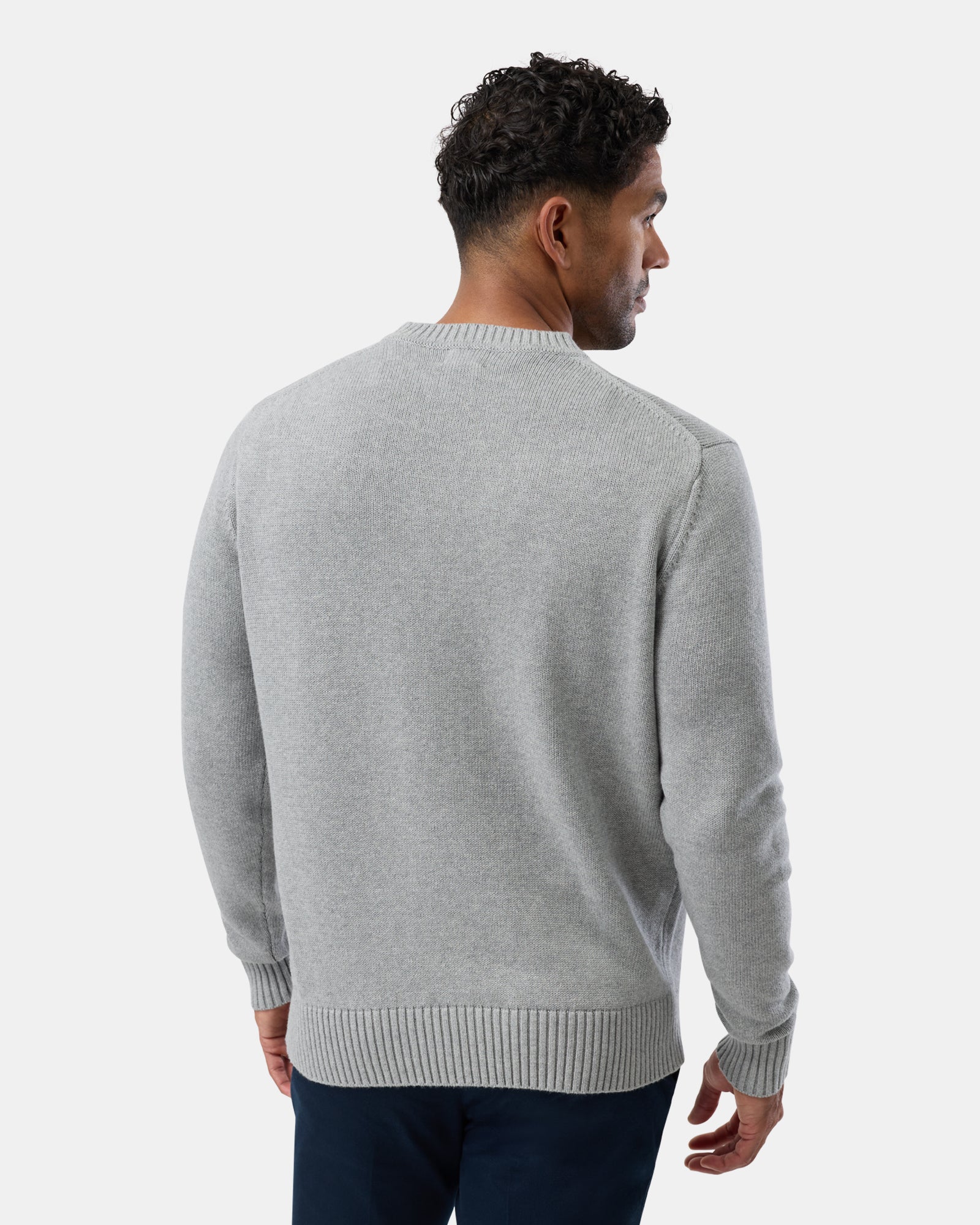 Man wearing a gray sweater on a white background, rear view