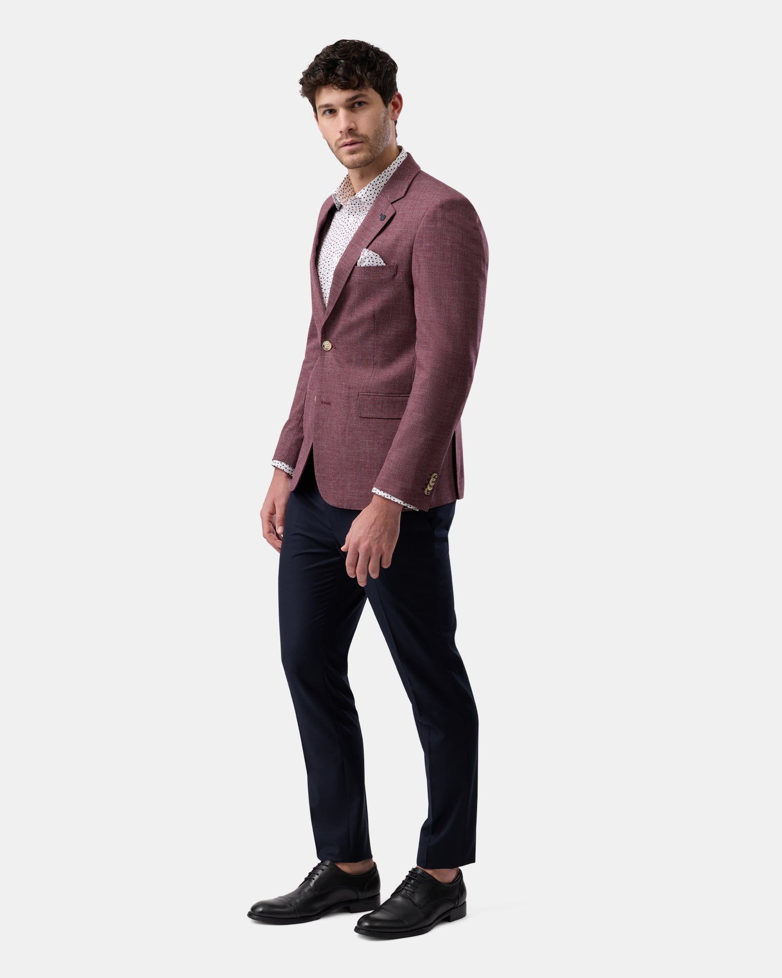 Profile of man wearing burgundy fully lined blazer, modern fit
