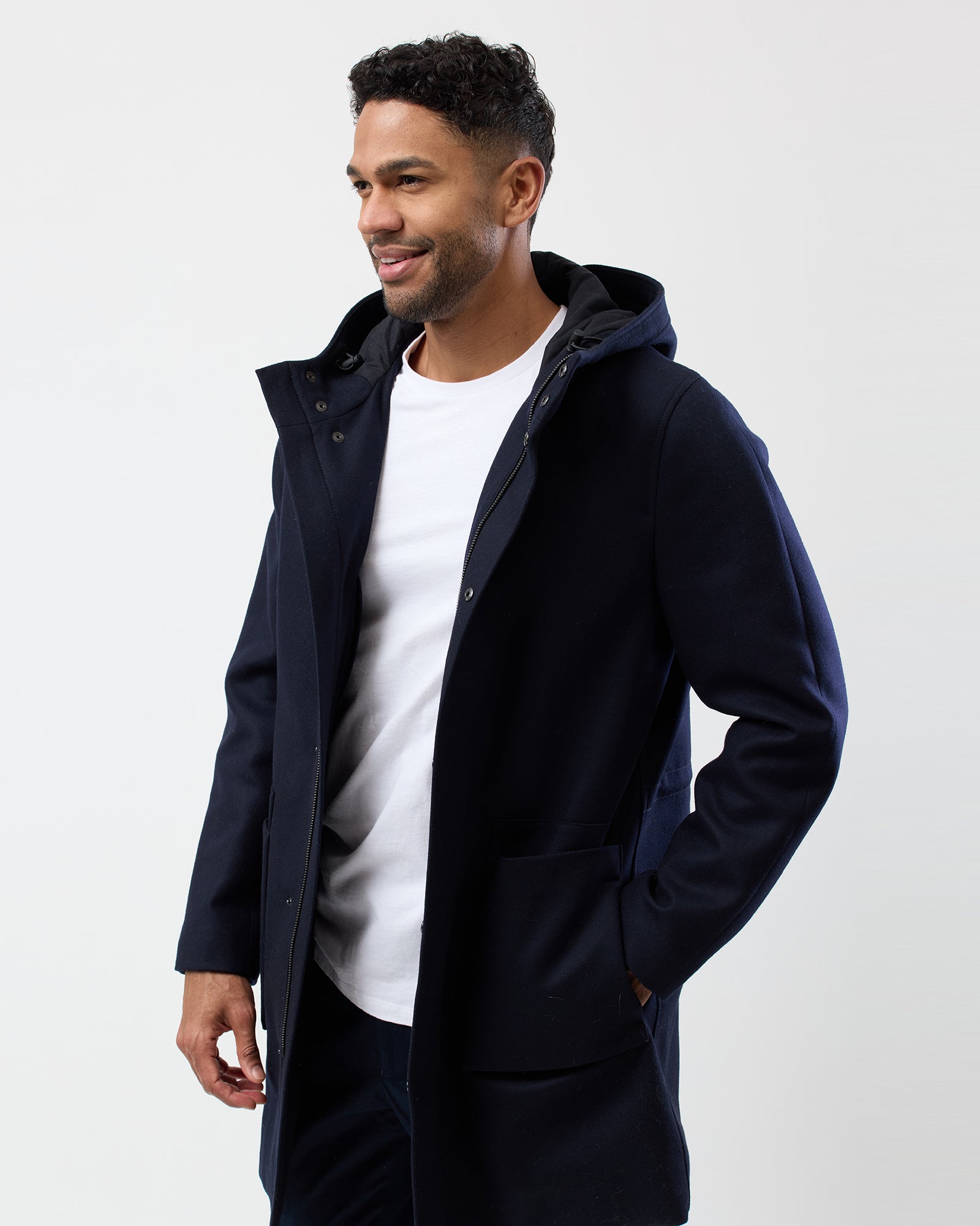 Man styled in navy hooded overcoat